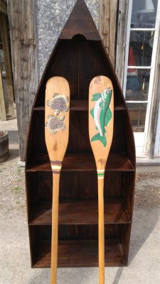 Wood Canoe Bookcase with a rich finish, 2 paddles painted with turtles and fish on either paddle